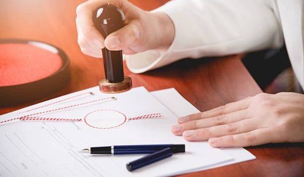 Woman Notary Public stamping the contract. Law office.
